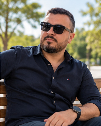 Marco Tulio, de óculos escuros e camisa azul-marinho, sentado ao ar livre